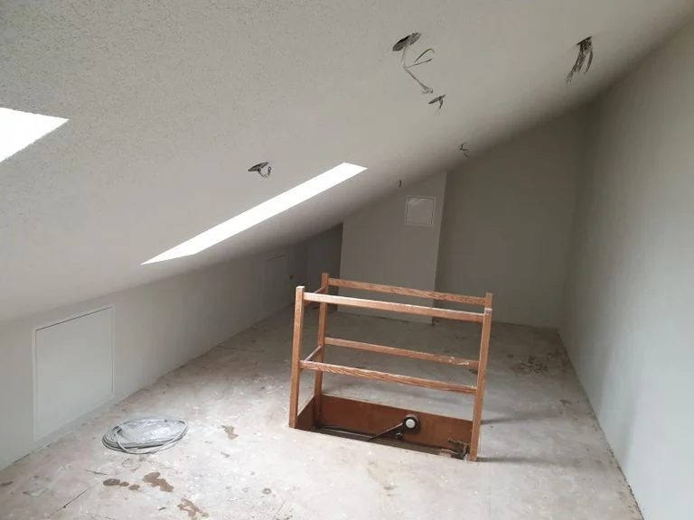 Ausgebauter Dachboden mit weißen Schrägen und Holzboden
